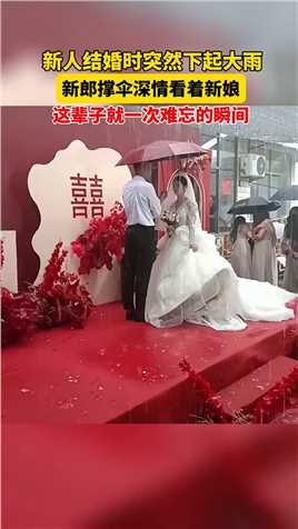 新人结婚时突然下起大雨，新郎撑伞深情的看着新娘。