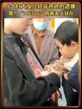 11月12日杭州交警陈蔚因公殉职，八岁的女儿轻轻抚摸着父亲的遗像。警号“116866”，将被永久封存...