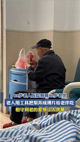 88岁老人医院照顾82岁老伴，老人用估计把梨弄成薄片给老伴吃，相守到老的爱情让人羡慕