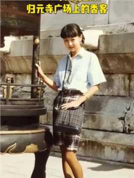 这是1988年湖北武汉，归元寺广场上的一位香客！照片中的姑娘，穿着冰蓝色短衬衫和棕色格子裙，她身材高挑，青春时尚，简直是个完美的姑娘！