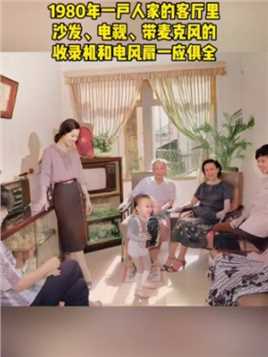 这张照片拍摄于1980年，一户人家的客厅里，沙发、电视、带麦克风的收录机和电风扇，一应俱全，家人的穿着也很时尚！