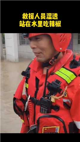 救援人员湿透，站在水里吃辣椒