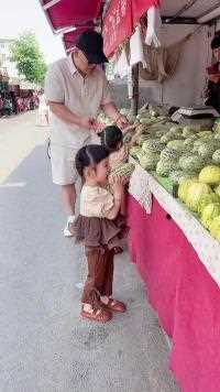 刚到菜市场爸爸正忙着和姐姐挑瓜，妹妹拿起甜瓜就啃，可把老板高兴坏了！#双胞胎