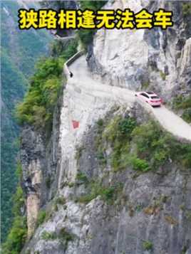 重庆深山里的一条挂壁公路，狭路相逢无法会车，脚下就是千米悬崖，这该怎么办呢？