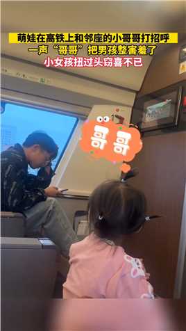 萌娃在高铁上和邻座的小哥哥打招呼，一声“哥哥”把男孩整害羞了，小女孩扭过头窃喜不已。