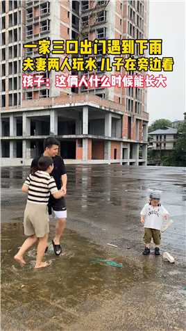一家三口出门遇到下雨，夫妻两人玩水，儿子在旁观看。网友这俩人什么时候能长大#家有萌娃 