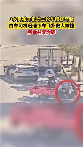 3岁男孩开机动三轮车横穿马路，白车司机迅速下车飞扑救人被撞，所幸并无大碍。