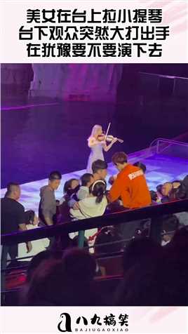 美女在台上拉小提琴，台下观众突然大打出手，在犹豫要不要演下去