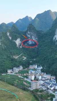 广西河池的凤山县就有这么一处奇景，一座大山竟然穿了个大洞，不知是天然形成还是人工开凿？