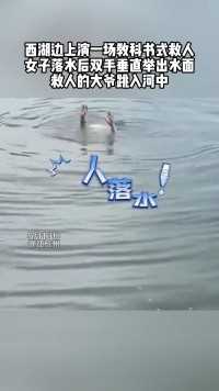 西湖边上演一场教科书式救人，女子落水后双手垂直举出水面，救人的大爷跳入河中