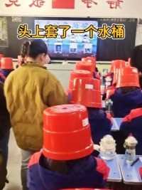学生们头上套了一个水桶，让家长找出自己的孩子