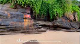 滴水丹屏位于涠洲岛滴水村南岸边，原名滴水岩。绝壁上部绿树成荫，壁上层间裂隙常有水溢出，一点点往下滴，如朱帘垂挂。
