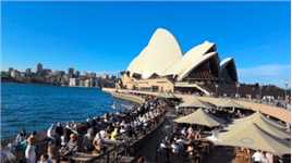 悉尼歌剧院坐落在悉尼港的便利朗角（Bennelong Point），其特有的帆造型，加上作为背景的悉尼海港大桥，与周围景物相互呼应。这里人头攒动，非常热闹，不愧为悉尼标志性建筑，吸引众多游人到此打卡留影。