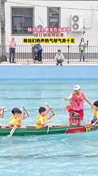 幼儿园小朋友在泳池中进行划龙舟比赛，萌娃们奶声奶气却气势十足