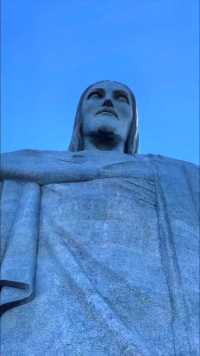 ＂里约热内卢基督像（救世基督像，葡萄牙语：Cristo Redentor） 也叫巴西基督像，是一座装饰艺术风格的大型耶稣基督雕像，位于巴西的里约热内卢基督山上，是该市的标志，也是世界最闻名的纪念雕塑之一。＂