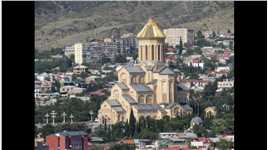 第比利斯的圣三一主教座堂，位于库拉河左岸的伊利亚山上。它是格鲁吉亚东正教会的主要大教堂，建于1995年至2004年间，是高加索地区最大的东正教教堂，也是世界上最大的宗教建筑之一。它的穹顶为7.5米高，全部包着纯金，闪闪发光，这些黄金都是格鲁吉亚人捐赠出来的。