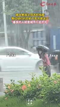 雨中男孩头顶书包挡雨
等红绿灯的司机下车为其送伞
“善良的人就是城市行走的光”