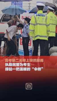 6月8日，重庆，高考第二天早上突降雨，执勤民警为考生撑起一把温暖的“伞桥”。 （上游新闻记者 徐勤）