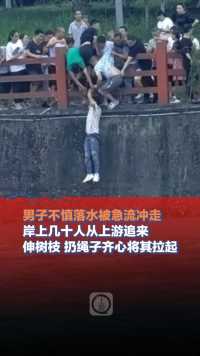 6月15日，四川成都，男子不慎落水被急流冲走，岸上几十人从上游追来，伸树枝 扔绳子齐心将其拉起。