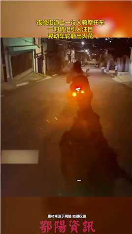 夜晚街道上一行人骑摩托车，一对情侣引人注目，晃动车轮磨出火花.