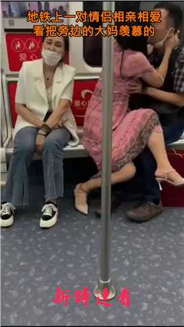 地铁上一对情侣相亲相爱，看把旁边的大妈羡慕的