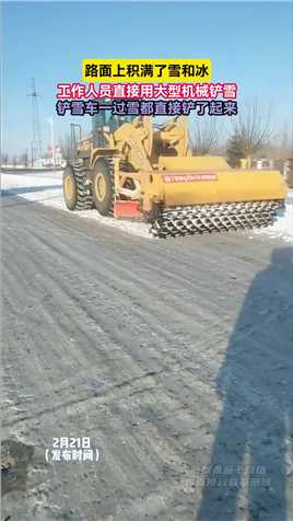 路面上积满了雪和冰，工作人员直接用大型机械铲雪