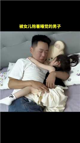 被女儿抱着睡觉的男子