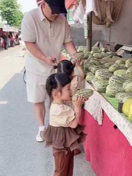 刚到菜市场爸爸正忙着和姐姐挑瓜，妹妹拿起甜瓜就啃，可把老板高兴坏了！.