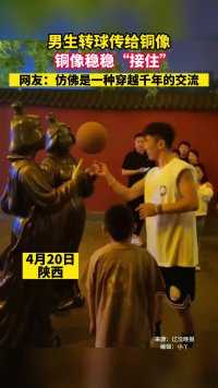 男生转球传给铜像，铜像稳稳“接住”，网友：仿佛是一种穿越千年的交流。