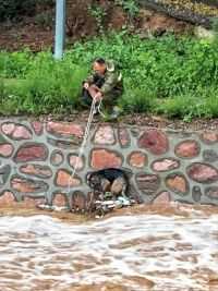 狗狗在洪水中挣扎了很久，已经没有力气爬上岸，正绝望的时候，大爷伸出了援手