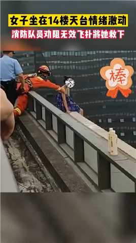 女子坐在14楼天台情绪激动，消防队员劝阻无效飞扑将她救下
